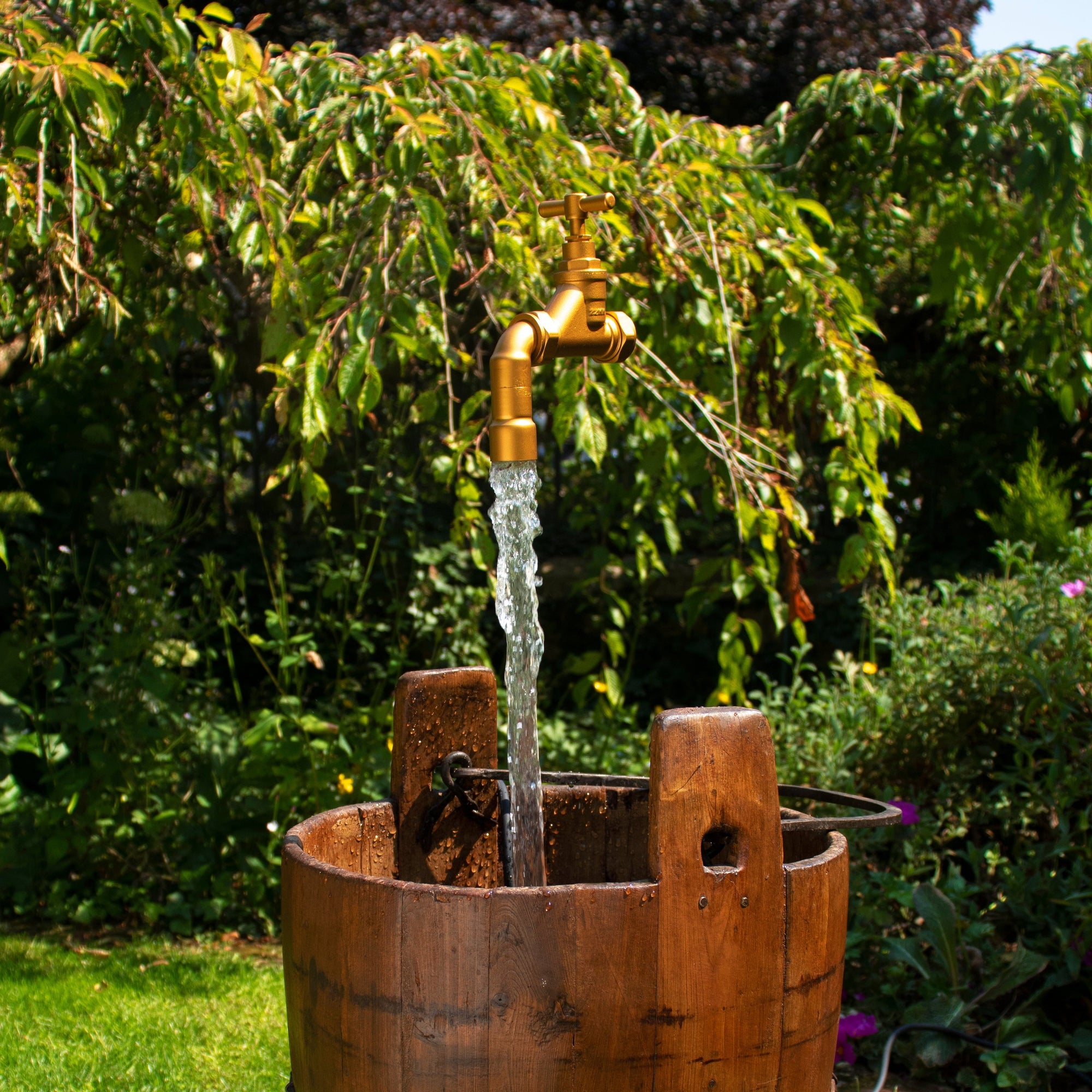 a floating tap suspended magically over a wooden antique pail